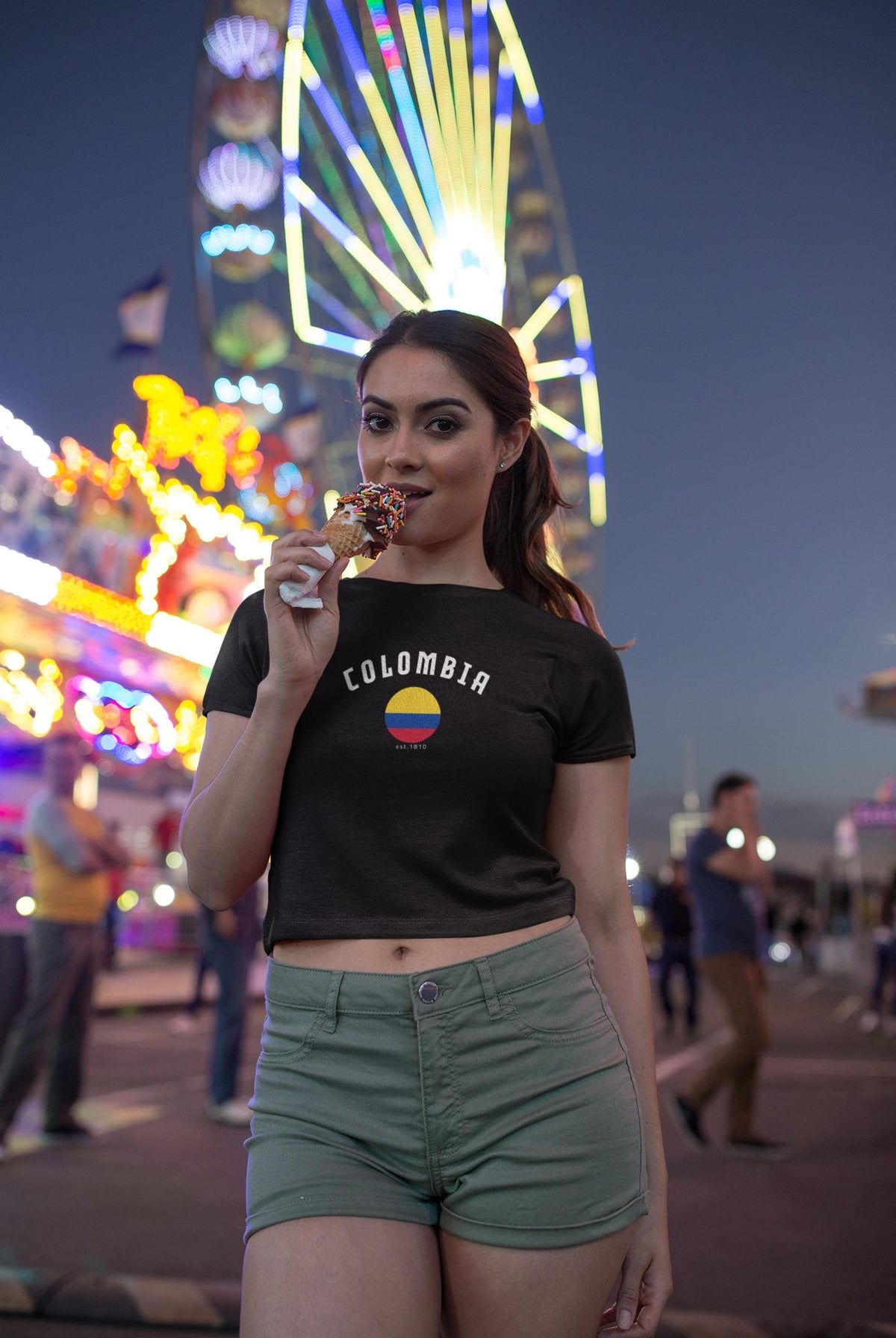 Black baby tee with arched Colombia text and round Colombian flag graphic, est. 1810