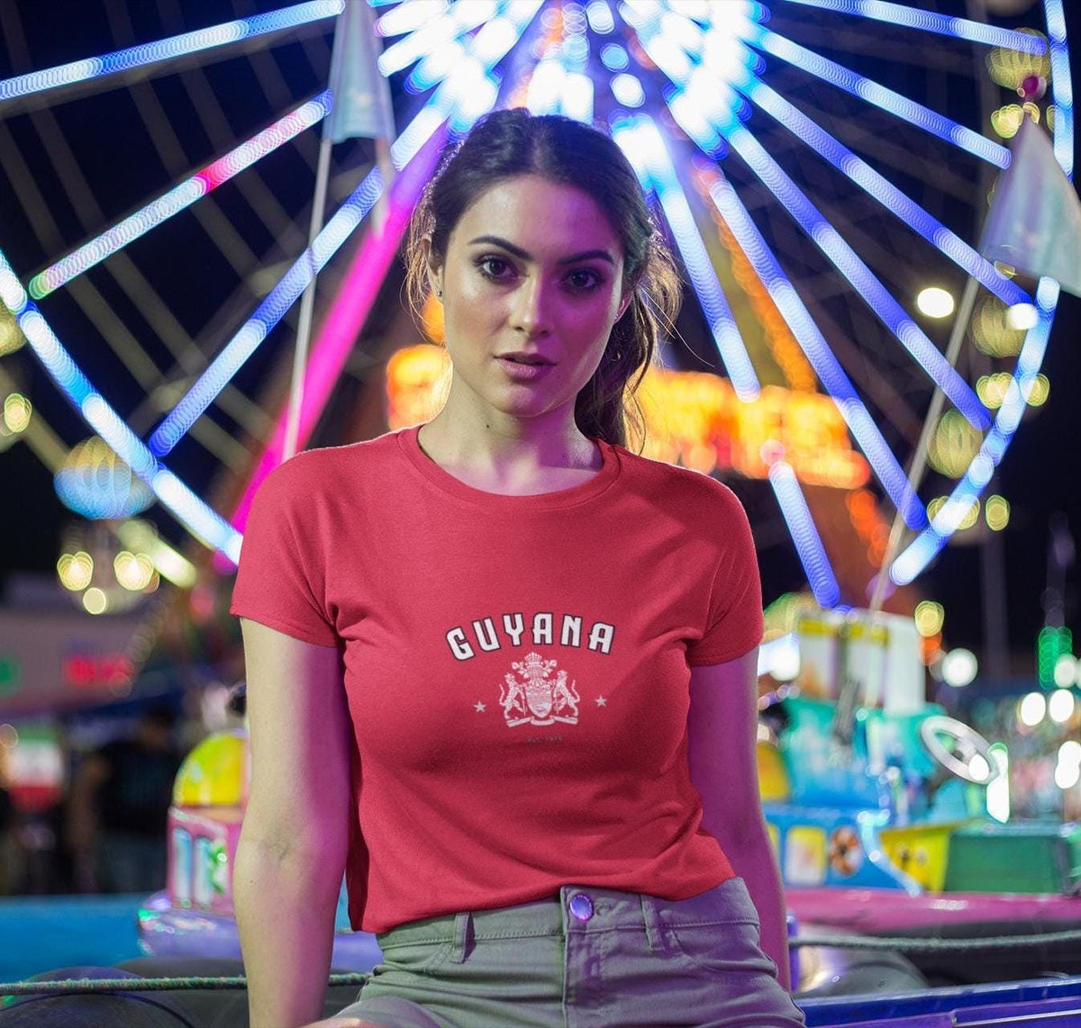 Red baby tee with arched Guyana lettering, white crest graphic, and star accents