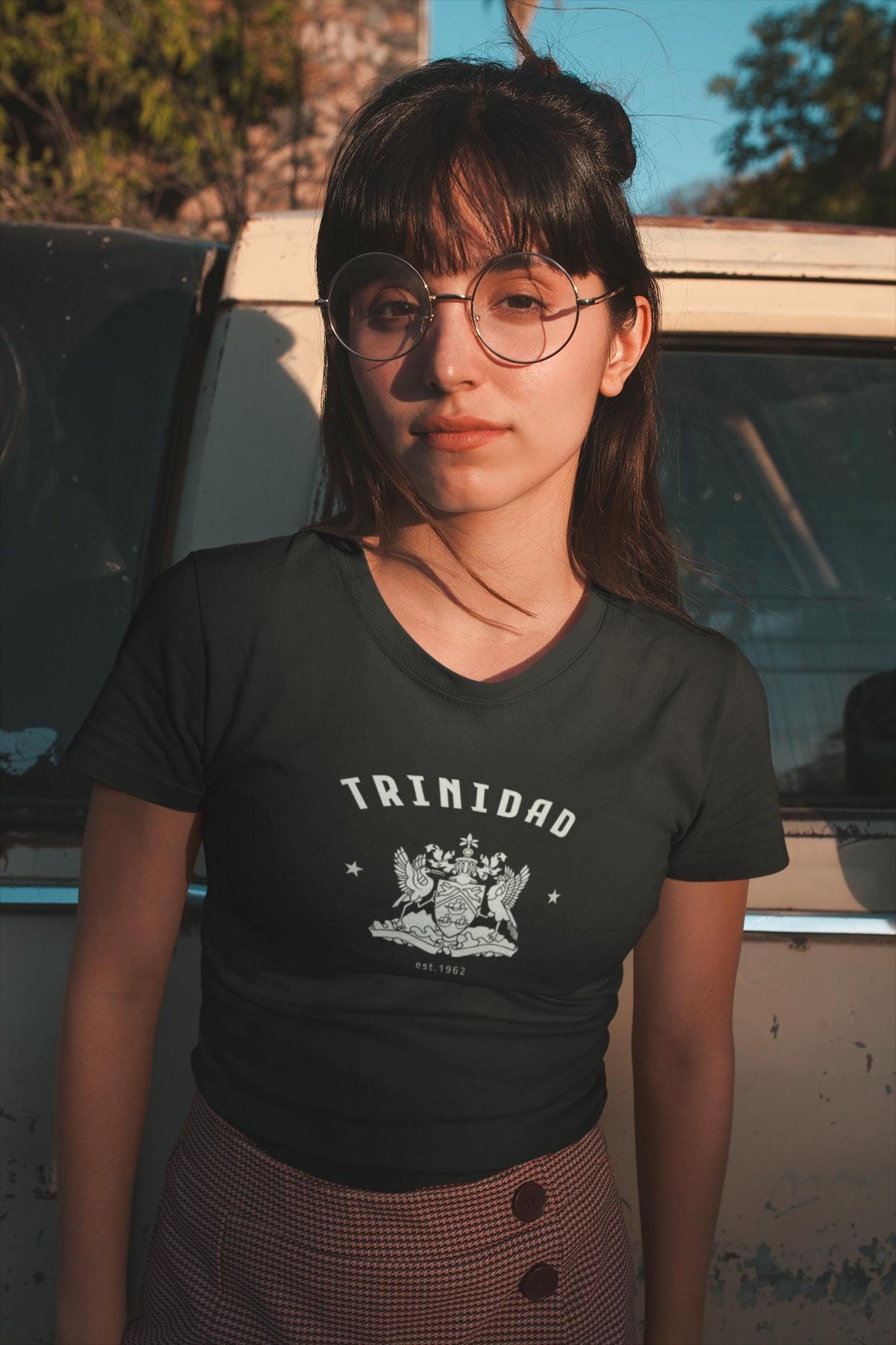 Red Trinidad baby tee with arched text, crest artwork, and star accents