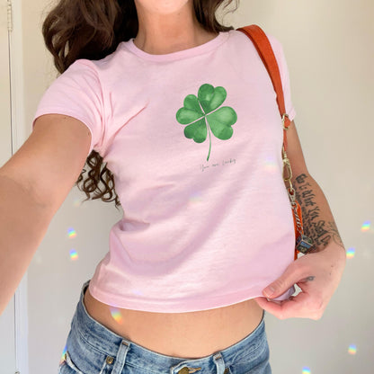 White baby tee with green four leaf clover artwork and small You are lucky text