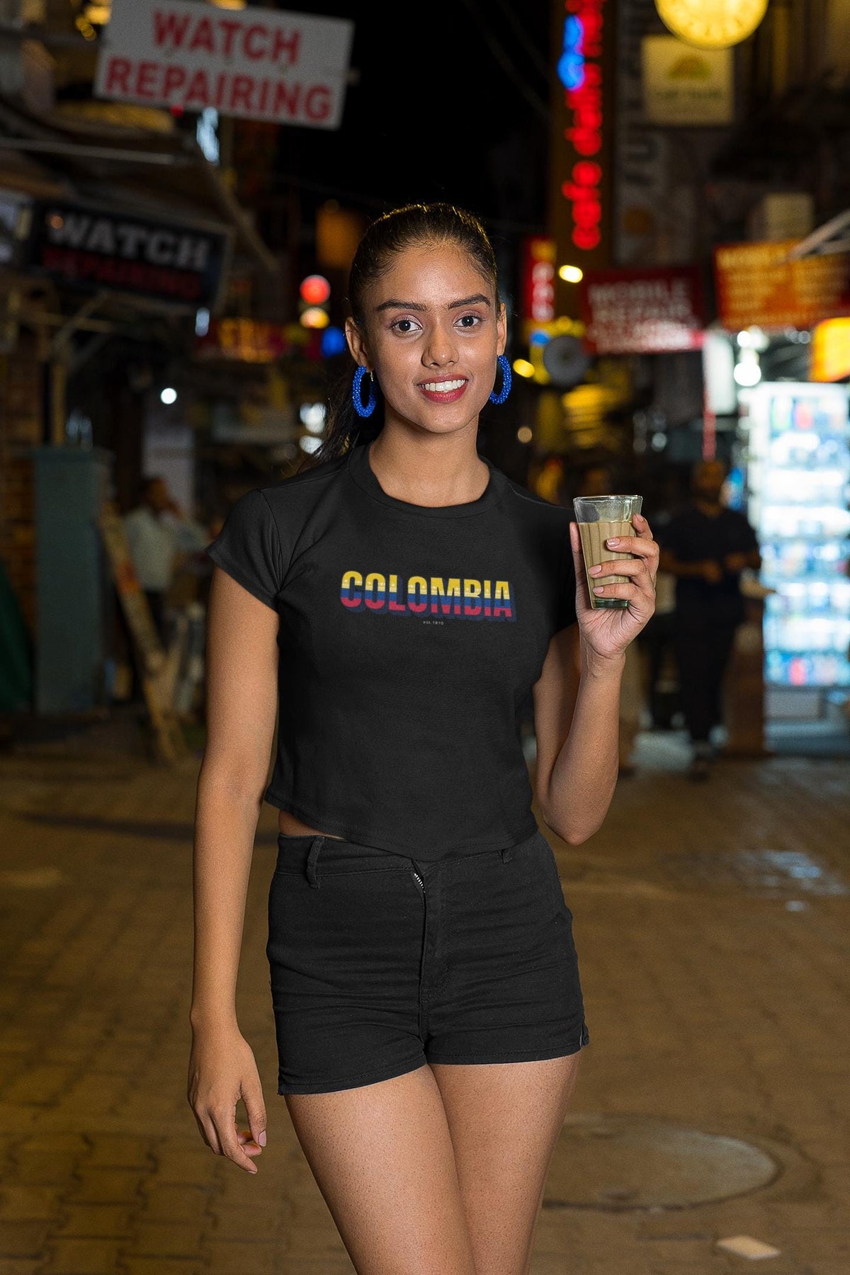 Yellow baby tee with a Colombia wordmark in flag colors on the chest
