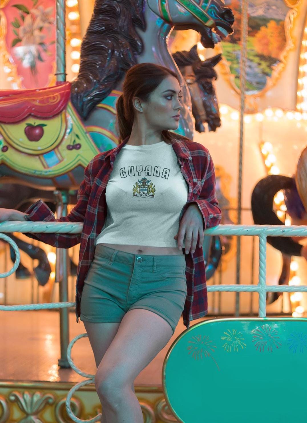 Yellow Guyana baby tee with arched lettering and crest graphic on the front