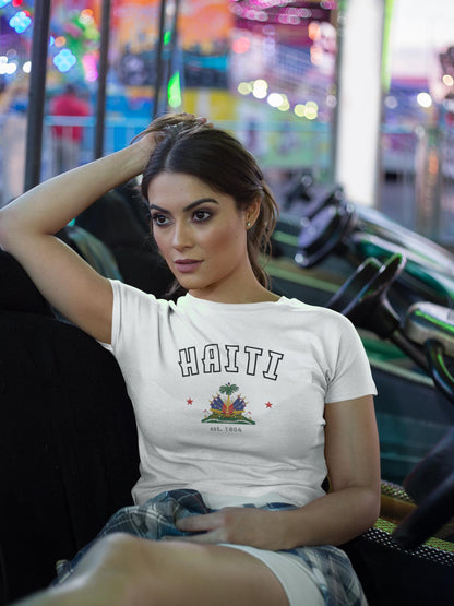 Blue baby tee with arched HAITI lettering, crest-style artwork, stars, and est. 1804 text