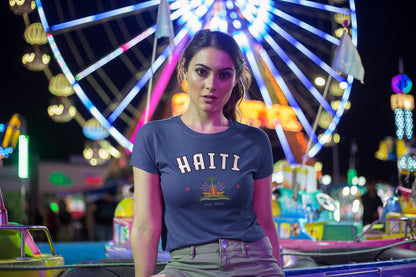 Blue baby tee with arched HAITI lettering, crest-style artwork, stars, and est. 1804 text