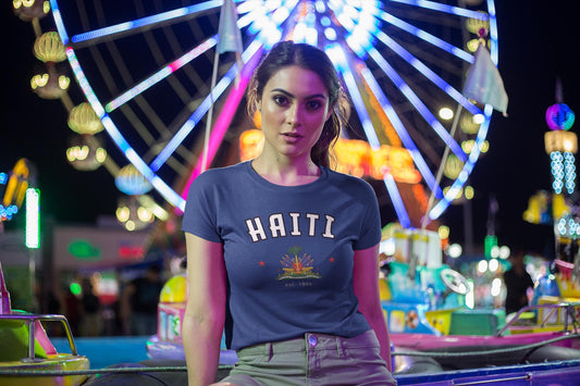 Blue baby tee with arched HAITI lettering, crest-style artwork, stars, and est. 1804 text