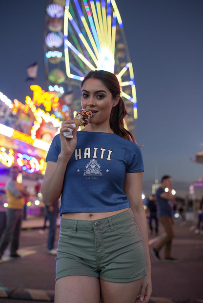 Blue baby tee with Haiti collegiate lettering, coat of arms graphic, stars, and est. 1804 text