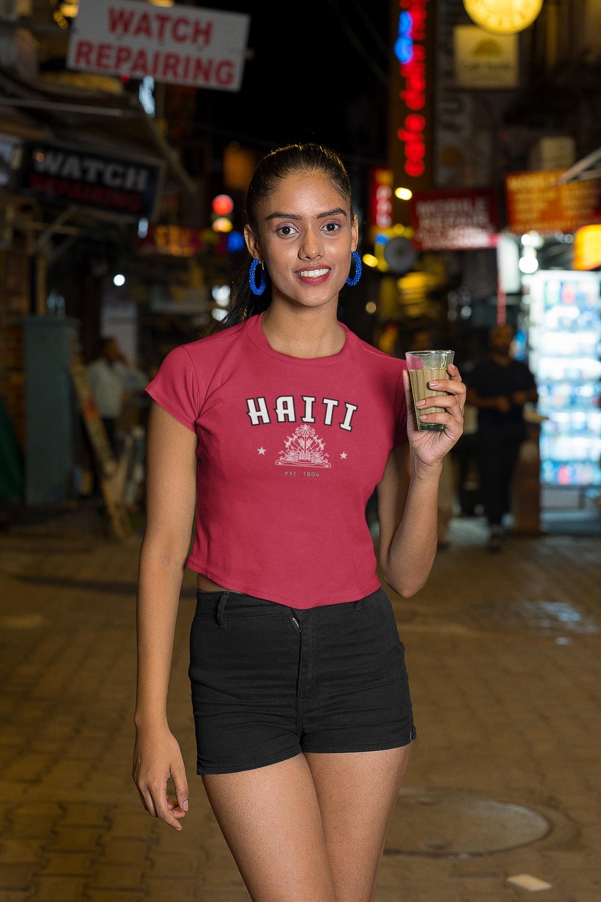 Blue baby tee with Haiti collegiate lettering, coat of arms graphic, stars, and est. 1804 text