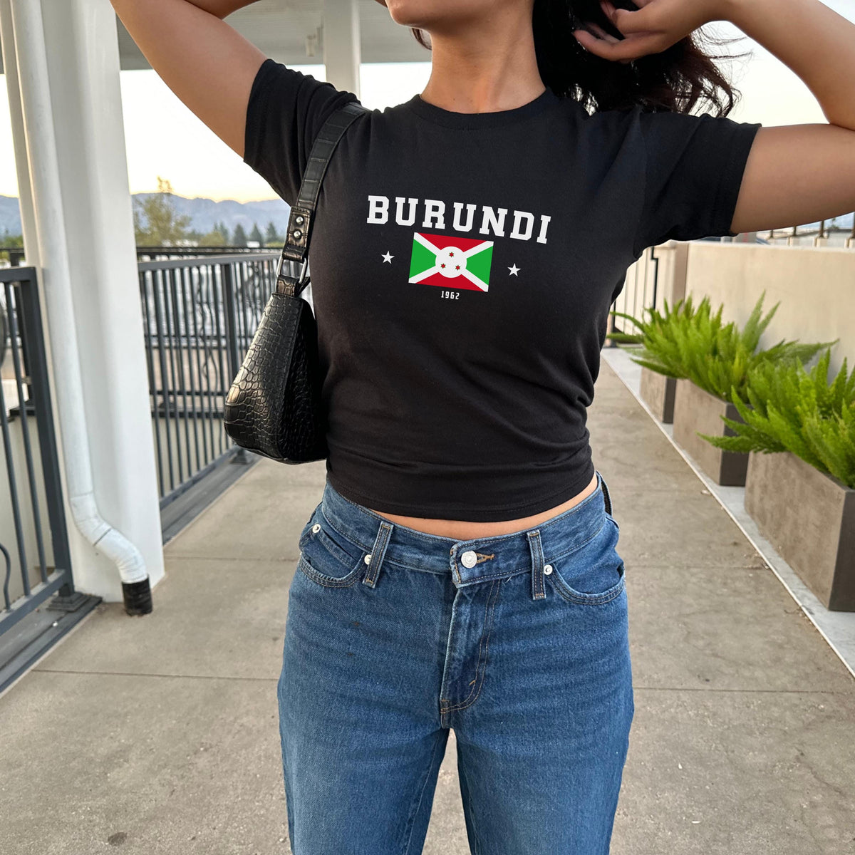 Red baby tee with BURUNDI varsity lettering, Burundi flag graphic, stars, and 1962.