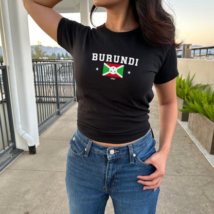 Red baby tee with BURUNDI varsity lettering, Burundi flag graphic, stars, and 1962.