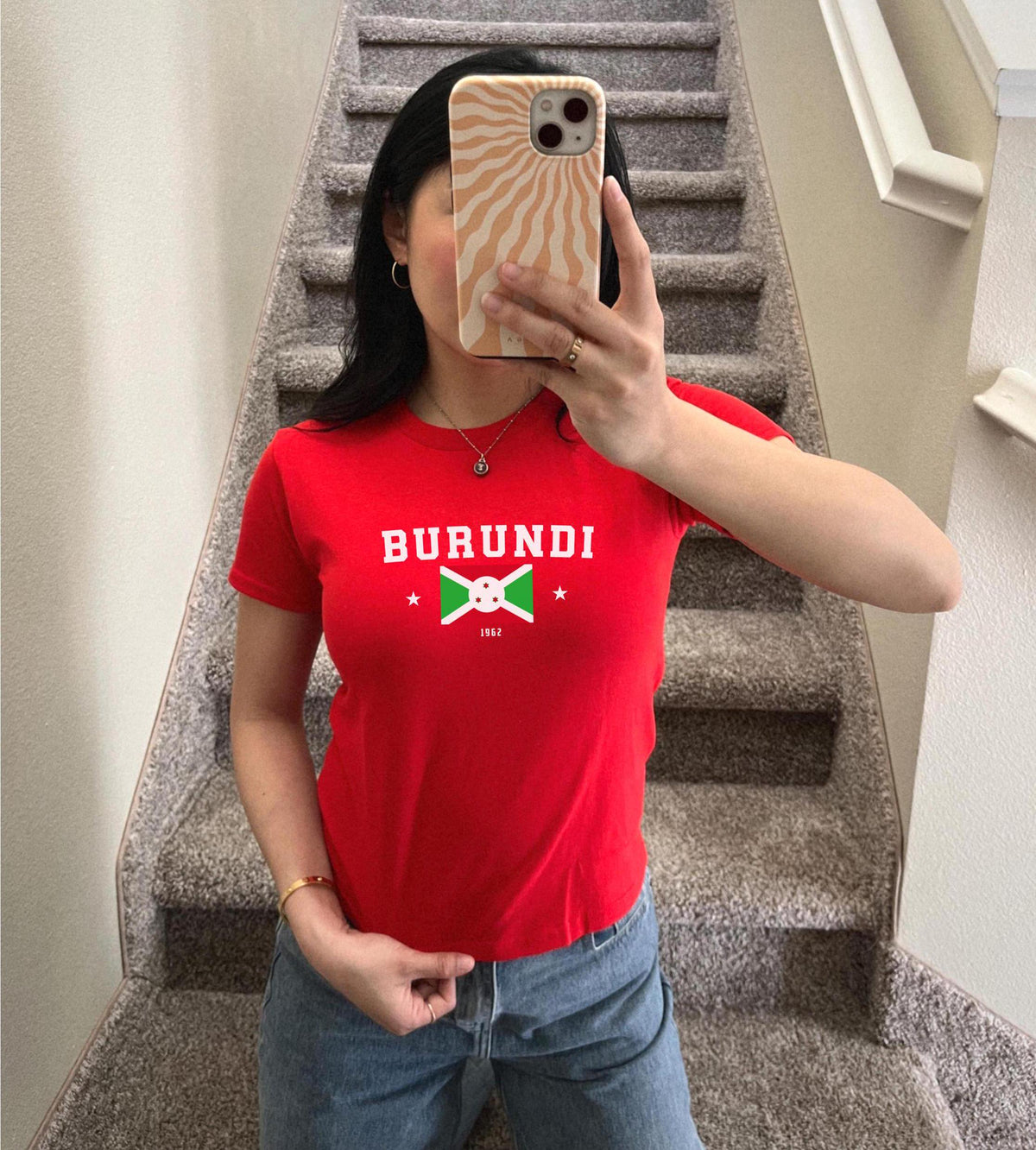 Red baby tee with BURUNDI varsity lettering, Burundi flag graphic, stars, and 1962.