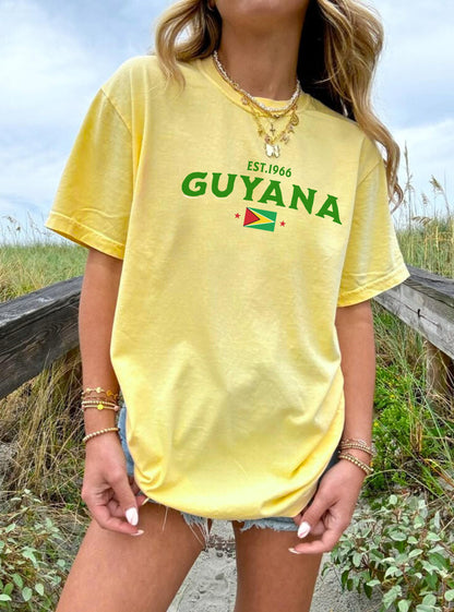 Black T-shirt with EST.1966 Guyana lettering, Guyana flag graphic, and star accents