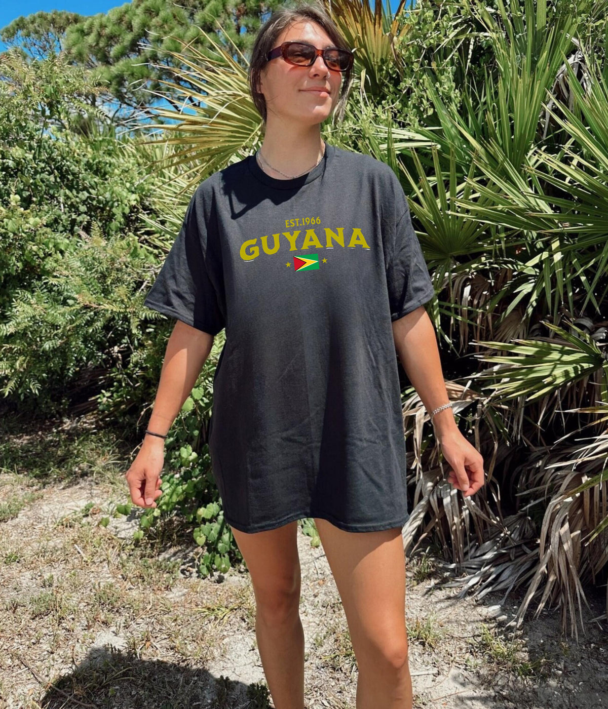 Black T-shirt with EST.1966 Guyana lettering, Guyana flag graphic, and star accents