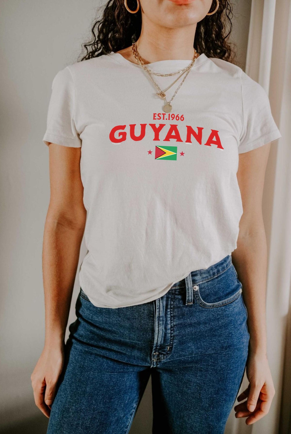 Black T-shirt with EST.1966 Guyana lettering, Guyana flag graphic, and star accents