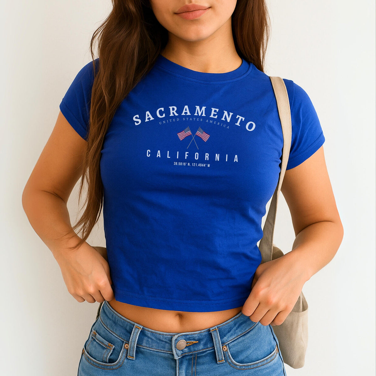 Sacramento California baby tee design with crossed American flags and coordinate text