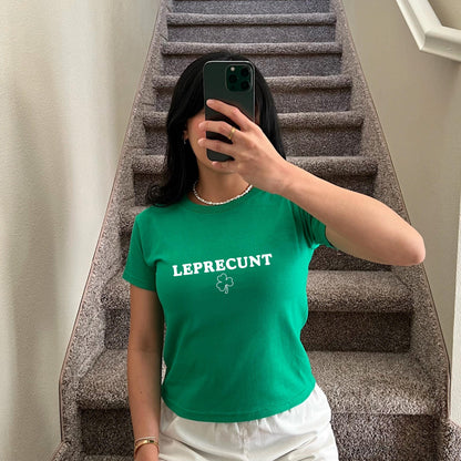 White baby tee with green LEPRECUNT lettering and a shamrock graphic