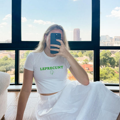 White baby tee with green LEPRECUNT lettering and a shamrock graphic