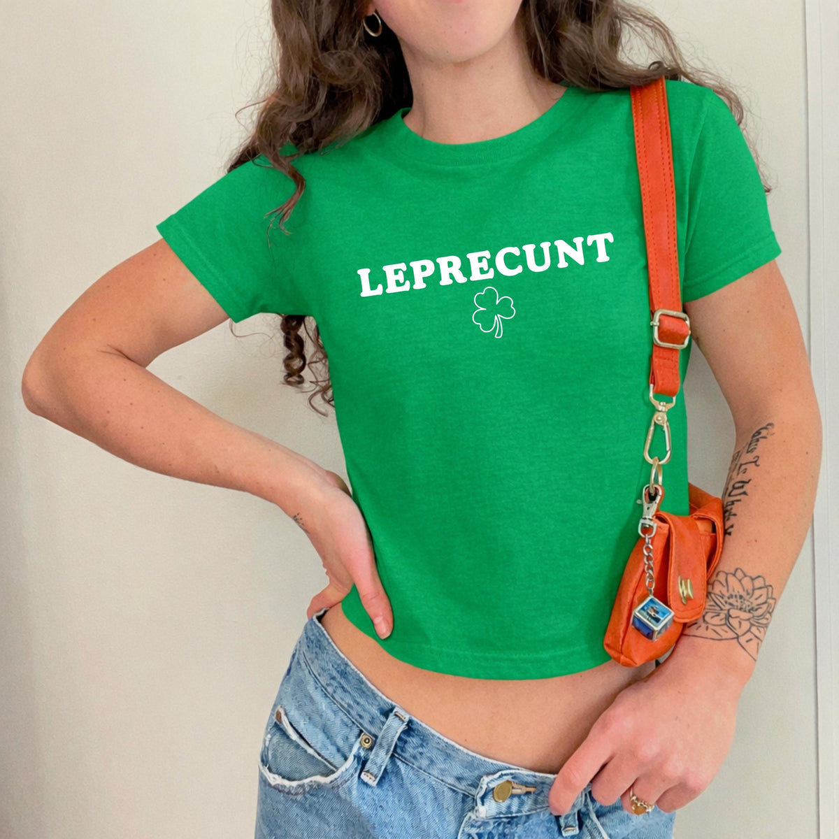 White baby tee with green LEPRECUNT lettering and a shamrock graphic