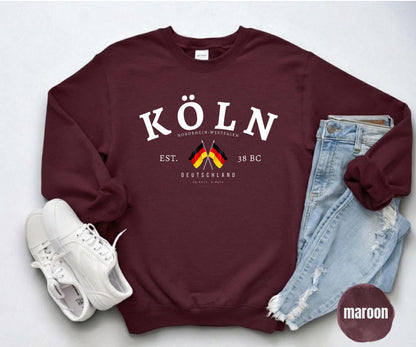 Maroon sweatshirt with white Köln text, Nordrhein-Westfalen details, and crossed German flags