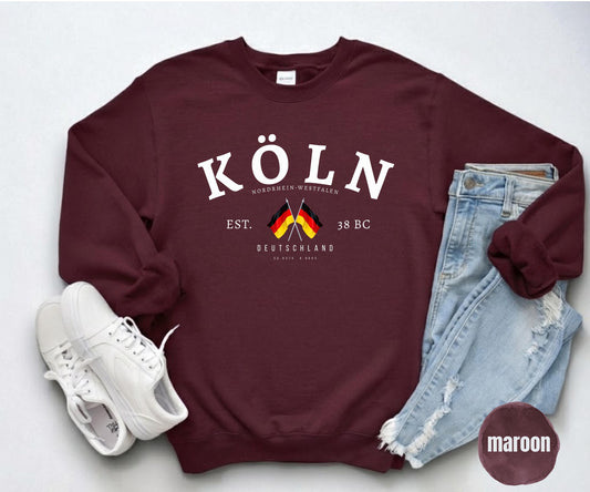 Maroon sweatshirt with white Köln text, Nordrhein-Westfalen details, and crossed German flags