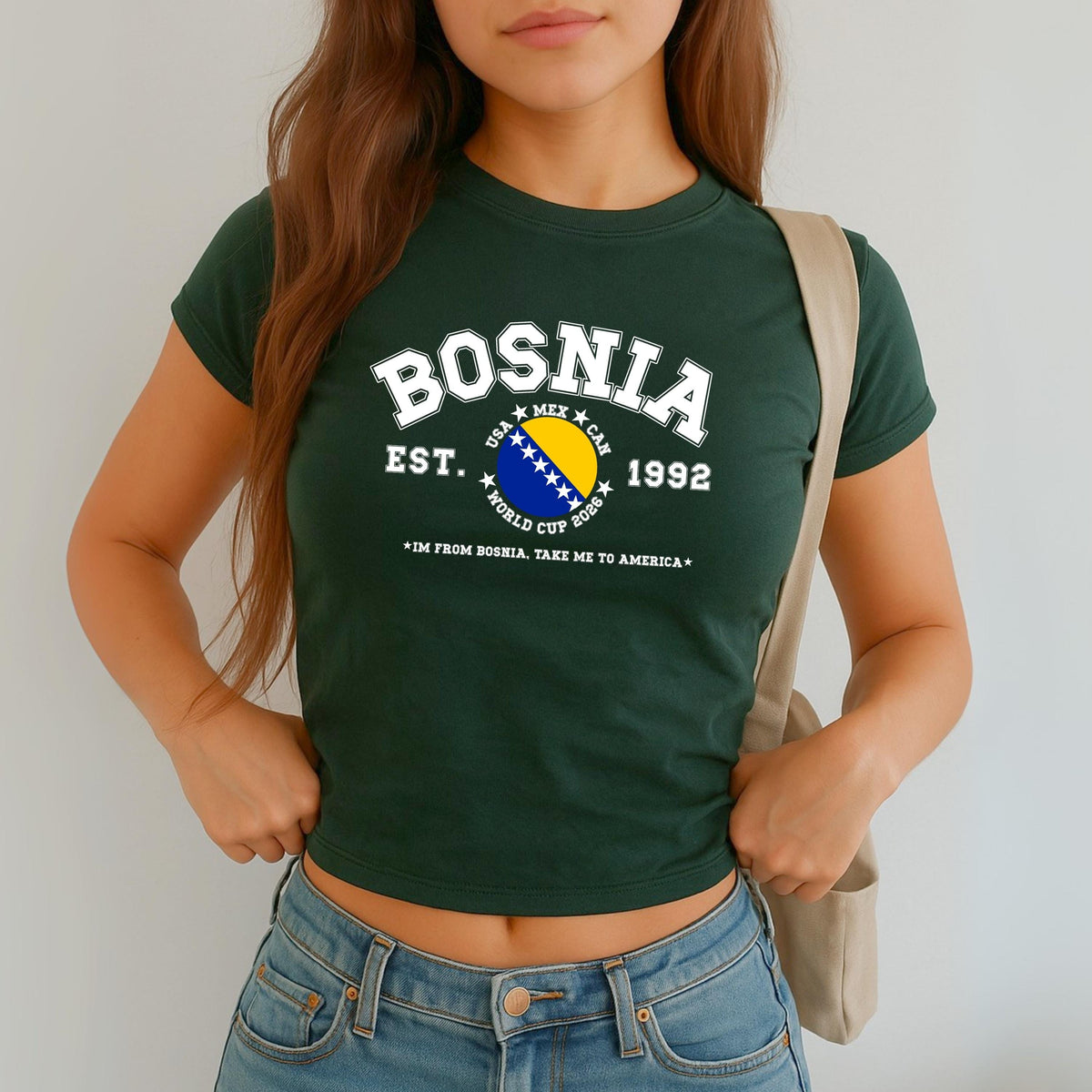 Blue Bosnia baby tee with collegiate flag design, World Cup 2026 text, and take me to America slogan
