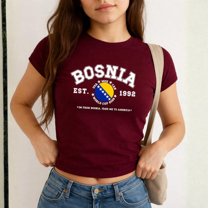 Blue Bosnia baby tee with collegiate flag design, World Cup 2026 text, and take me to America slogan