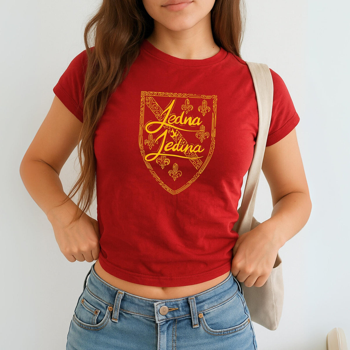 Blue baby tee with yellow Jedina si Jedina shield design and fleur-de-lis details