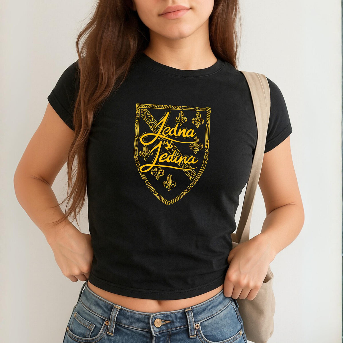 Blue baby tee with yellow Jedina si Jedina shield design and fleur-de-lis details
