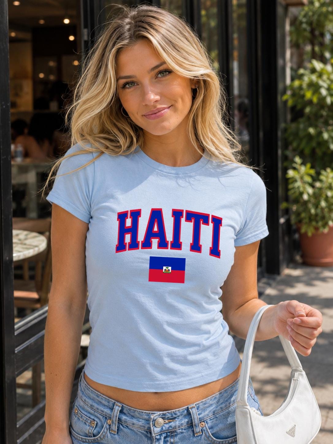 Navy baby tee with bold HAITI varsity lettering and Haitian flag graphic