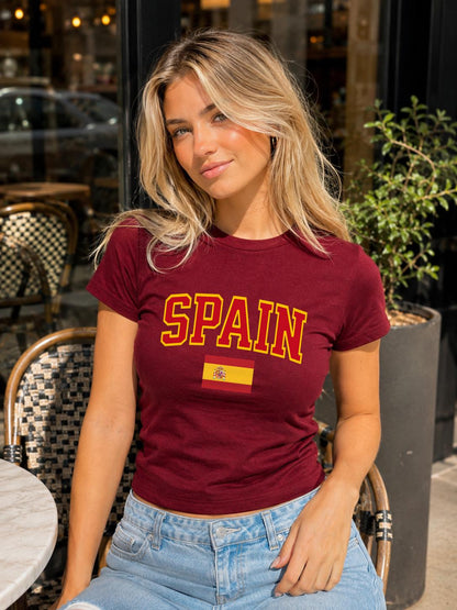 Spain baby tee with bold varsity lettering and Spanish flag graphic