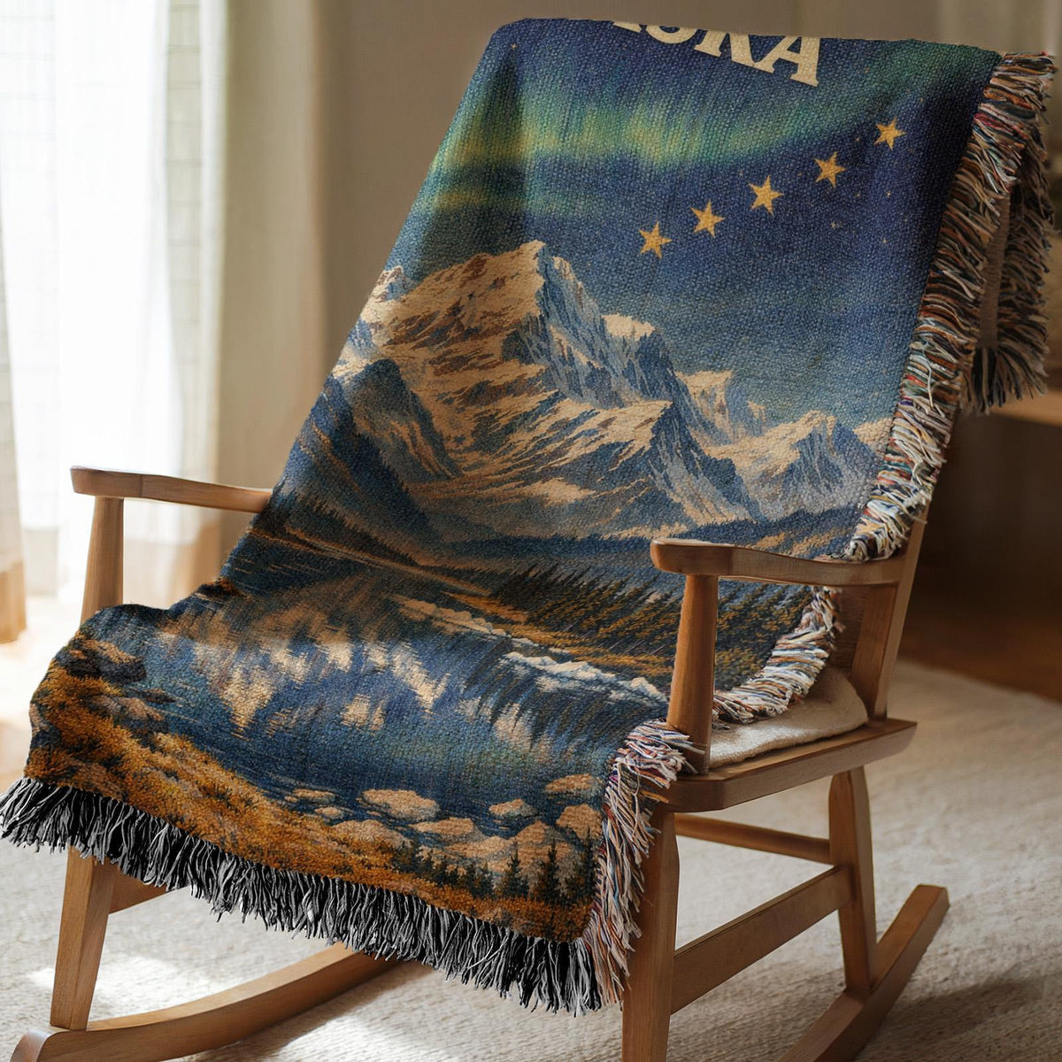 Alaska woven blanket with northern lights, mountain lake scene, gold stars, and fringe edges