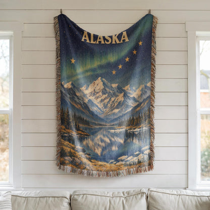 Alaska woven blanket with northern lights, mountain lake scene, gold stars, and fringe edges