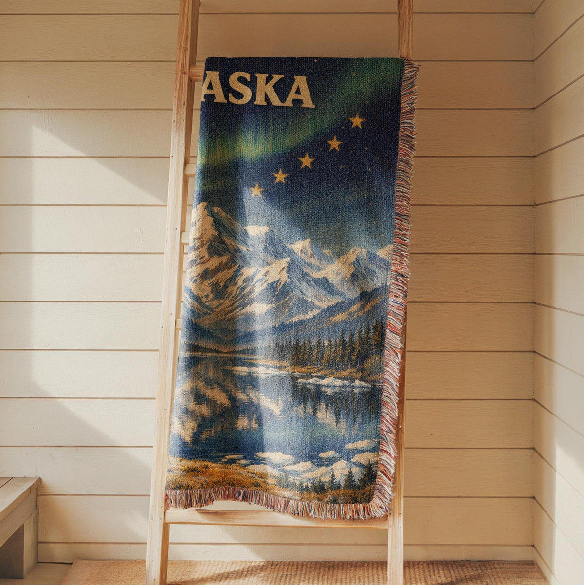Alaska woven blanket with northern lights, mountain lake scene, gold stars, and fringe edges