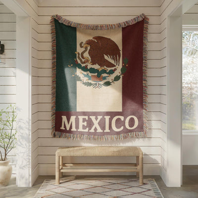 Woven blanket featuring the Mexico flag with eagle coat of arms and MEXICO text
