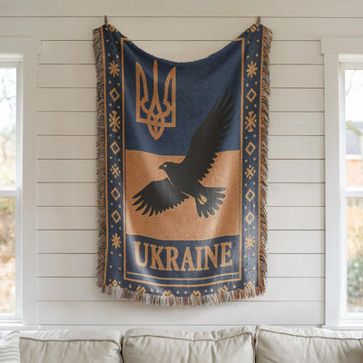 Woven Ukraine blanket with Tryzub trident, flying bird silhouette, folk border, and fringe edges