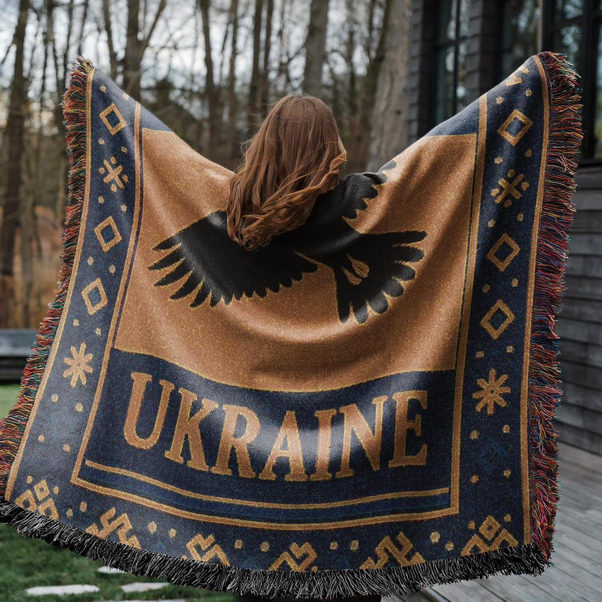 Woven Ukraine blanket with Tryzub trident, flying bird silhouette, folk border, and fringe edges