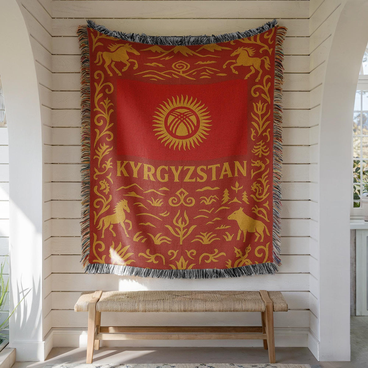 Red and gold Kyrgyzstan woven blanket with horses, mountains, ornamental borders, and fringe edges