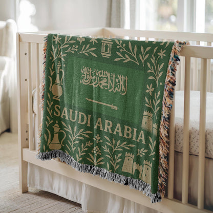 Green Saudi Arabia woven blanket with Arabic script, camel, palm trees, sword, lanterns, and fringe edges