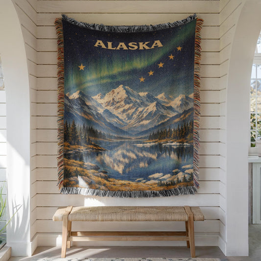 Alaska woven blanket with northern lights, mountain lake scene, gold stars, and fringe edges