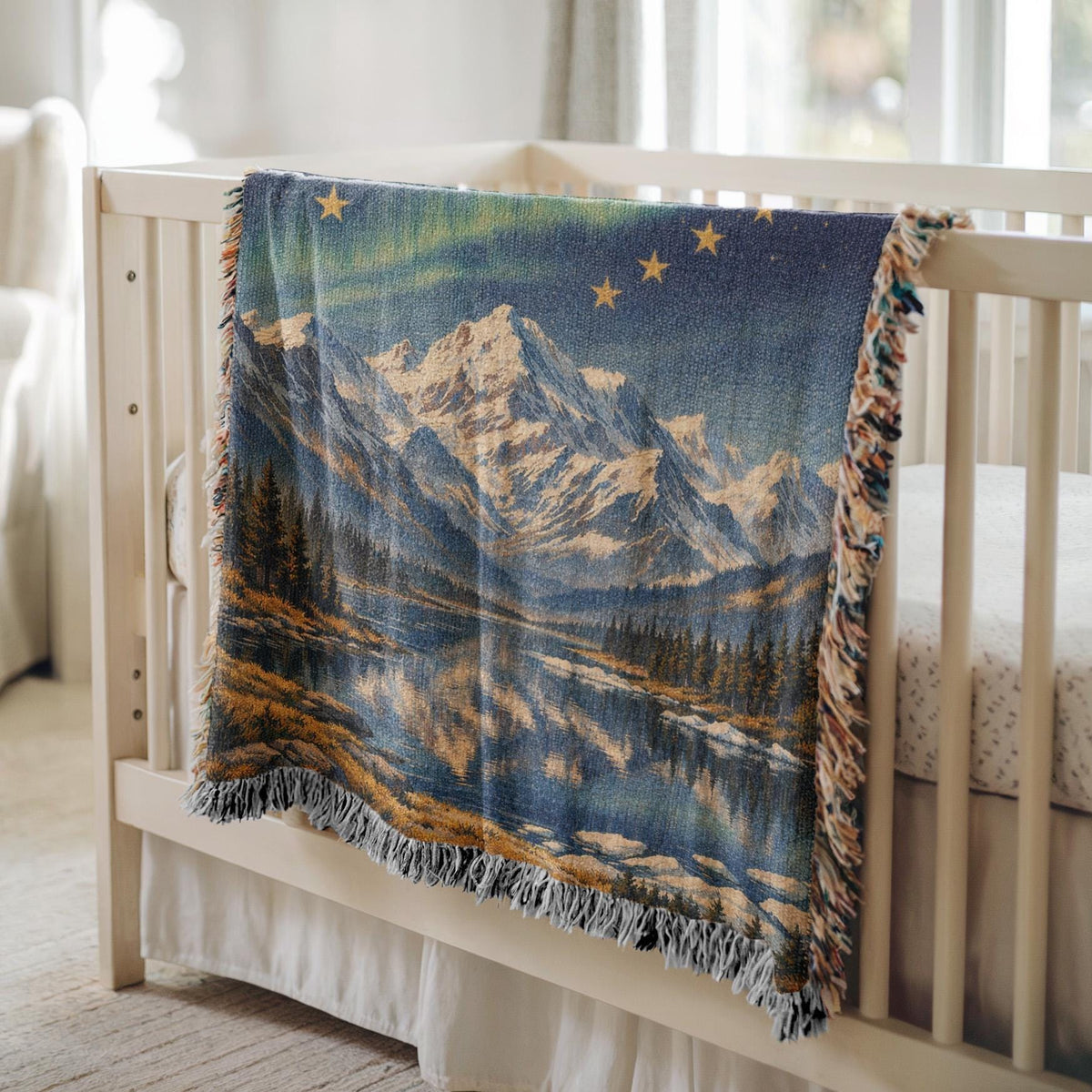 Alaska woven blanket with northern lights, mountain lake scene, gold stars, and fringe edges