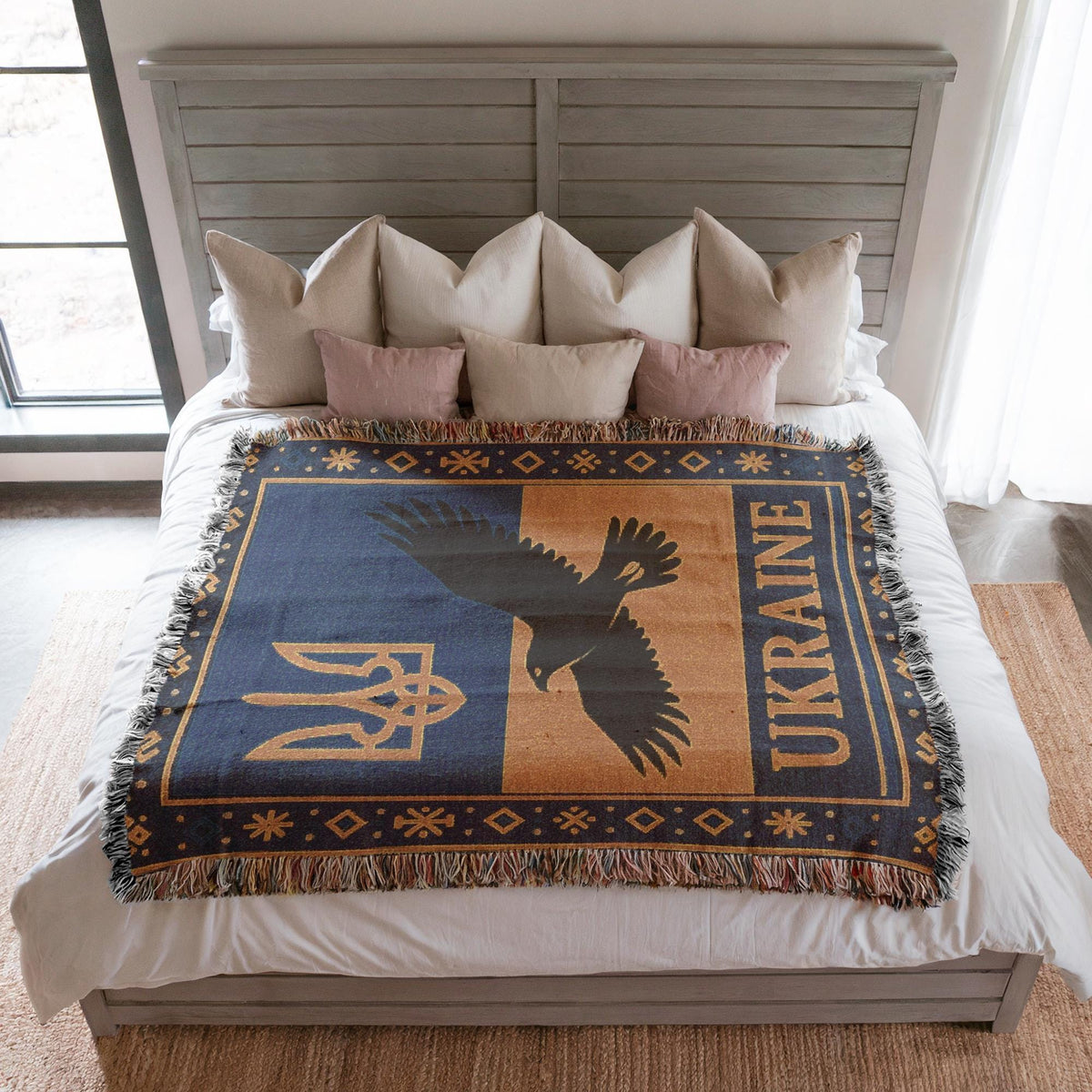 Woven Ukraine blanket with Tryzub trident, flying bird silhouette, folk border, and fringe edges