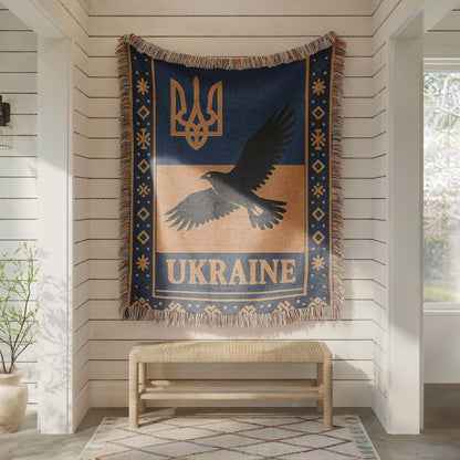 Woven Ukraine blanket with Tryzub trident, flying bird silhouette, folk border, and fringe edges