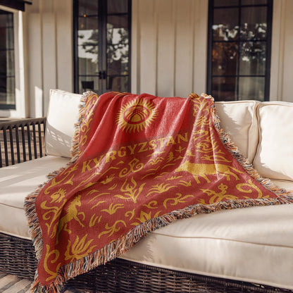 Red and gold Kyrgyzstan woven blanket with horses, mountains, ornamental borders, and fringe edges
