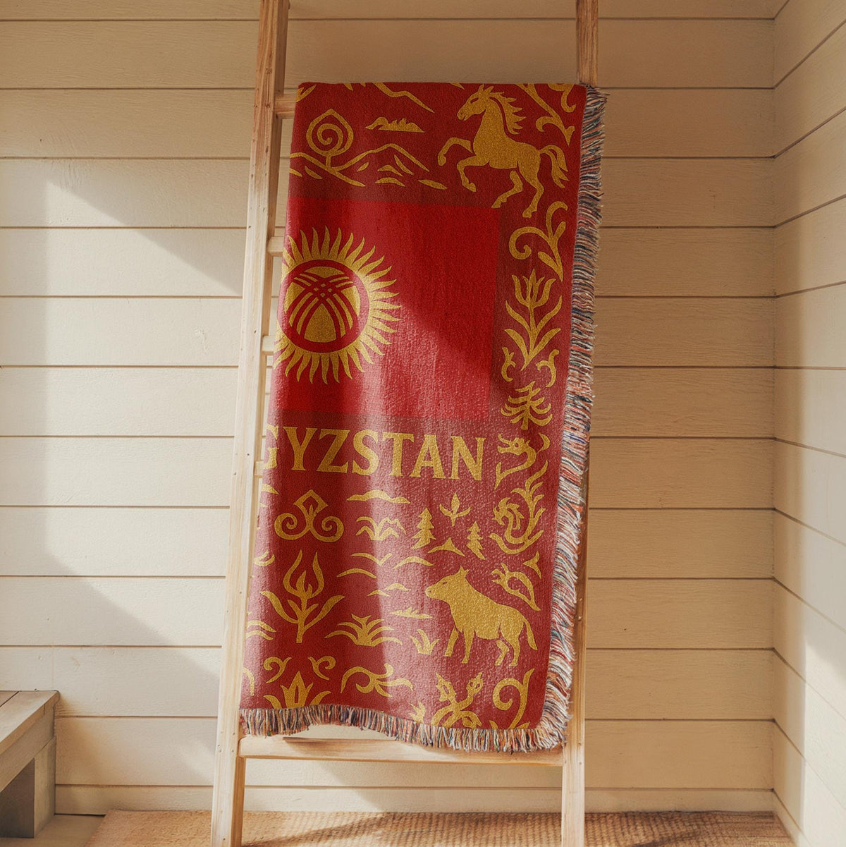 Red and gold Kyrgyzstan woven blanket with horses, mountains, ornamental borders, and fringe edges